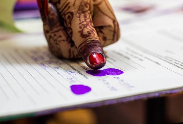 lady giving thumb impression on marriage registry certificate. Indian matrimony. Bengali weddding